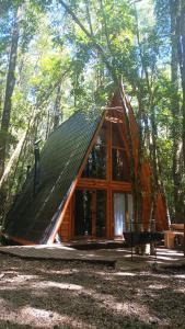 eine kleine Hütte im Wald mit Dach in der Unterkunft Casa Aurora in Puerto Fuy