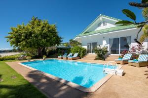 a swimming pool in front of a house at Beachfront Villa Baan Rim Haad 3BR in Lamai