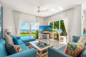 salon z niebieskimi meblami i widokiem na ocean w obiekcie Beachfront Villa Baan Rim Haad 3BR w mieście Lamai