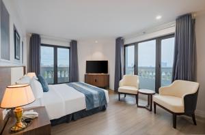 una camera d'albergo con un letto e due sedie di Rex Quang Binh Hotel a Dong Hoi