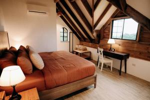 a bedroom with a bed and a desk in a room at The Old Country Stone House in Cebu City