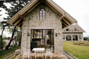 セブシティにあるThe Old Country Stone Houseの建物の前にテーブルと椅子