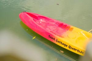 a yellow and pink kayak sitting in the water at Saint Cottage River Side in Batukaras