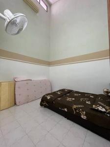a bedroom with a bed in the corner of a room at Hajjah Homestay Jln Rajawali Tg Agas in Muar