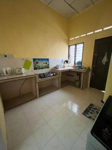 a kitchen with a counter and a stove in it at Hajjah Homestay Jln Rajawali Tg Agas in Muar