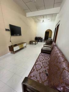 a living room with a couch and a flat screen tv at Hajjah Homestay Jln Rajawali Tg Agas in Muar