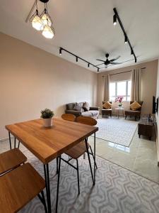 a living room with a table and a couch at Cozy Apartment 3 Br CityView In KT Near Drawbridge in Kuala Terengganu