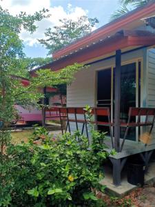 uma pequena casa com cadeiras num alpendre em Win Gray Homestay Resort em Pathiu