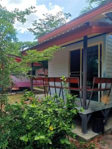 a tiny house with chairs on a porch at Win Gray Homestay Resort in Pathiu