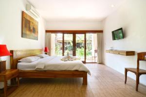 a bedroom with a bed and a table and chairs at Diuma residence yoga meditation retreat and healing Center in Denpasar