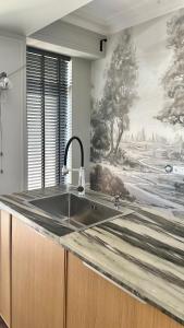 a kitchen with a sink and a painting on the wall at Logvinenko apartment in Bishkek