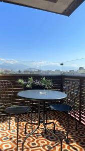 a table and chairs on a balcony with a view at Logvinenko apartment in Bishkek