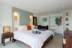 una camera da letto con un grande letto bianco con scarpe di Baan Suay Villa a Salad Beach