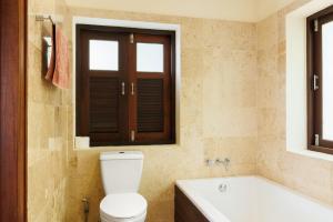 uma casa de banho com um WC, uma banheira e uma janela. em Baan Suay Villa em Salad Beach