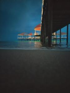 a pier on the beach next to the ocean at Bely Parus in Bosteri