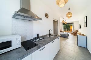 a kitchen with a microwave and a counter top at Résidence Touristique LES MASCARINS in Petite Île