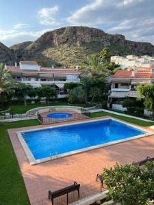 a large swimming pool with a mountain in the background at Bungalow Santa Pola del Este in Gran Alacant
