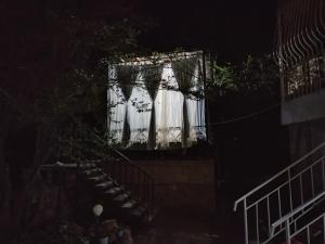 a white curtain on a balcony at night at Bely Parus in Bosteri