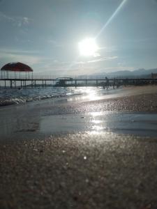 a beach with an umbrella and a pier at Bely Parus in Bosteri