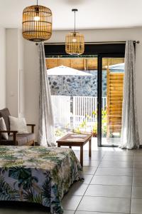 um quarto com uma cama e portas de vidro deslizantes em Résidence Touristique LES MASCARINS em Petite Île