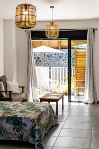 a bedroom with a bed and sliding glass doors at Résidence Touristique LES MASCARINS in Petite Île