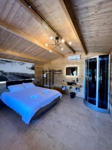 une chambre avec un grand lit et un plafond en bois dans l'établissement Les Chalets de Tesa, à Occhiatana