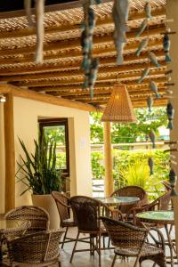 an outdoor patio with tables and chairs and a ceiling at Hotel Porto Dourado - Rede Bem Bahia in Porto Seguro
