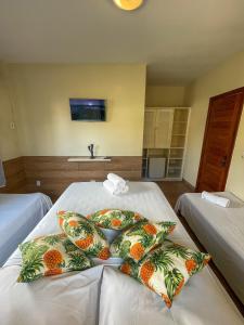 a hotel room with two beds with pineapple pillows at Hotel Porto Dourado - Rede Bem Bahia in Porto Seguro