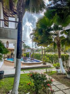 um resort com palmeiras e uma piscina em Hotel Porto Dourado - Rede Bem Bahia em Porto Seguro