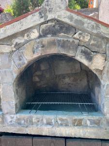un horno en una pared de piedra con una rejilla en Villa rustica bougainvillea en Maslinica
