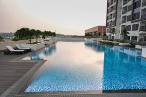 a large swimming pool in the middle of a building at Lovina 1811 Harbourbay Residence in Batu Ampar