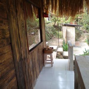 Una puerta de madera a una casa con una cesta. en Lumbung Langit Guest Home, en Gianyar