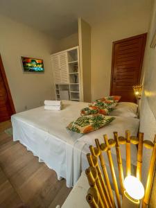 1 cama con sábanas blancas y almohadas en una habitación en Hotel Porto Dourado - Rede Bem Bahia, en Porto Seguro