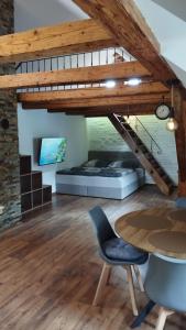 a loft with a bed and a table and chairs at Apartman Albreit 2 in Jáchymov
