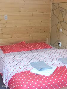 a bed with red and white polka dot sheets at ART House Transylvania , Valea Avrigului , Sibiu in Avrig
