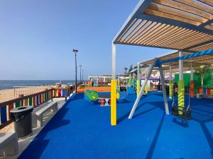a playground on the beach next to the ocean at Sunset Balcony with Ocean Views and pool access in Mogán