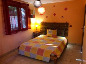布里昂松的住宿－Comme à la maison à la montagne，一间设有床铺的卧室,位于一个拥有橙色墙壁的房间