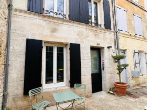 uma mesa e cadeiras em frente a um edifício em Bel appartement, Birds, Secteur Boinot - wifi, netflix em Niort