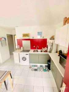 uma cozinha com um lavatório e uma máquina de lavar roupa em Alaia - Maisonnette T3 à 400m plage em Bidart