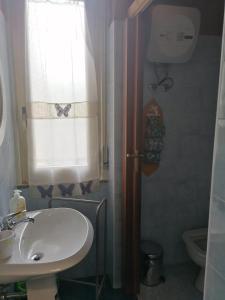 baño con lavabo y ventana en Dal corso al mare, en Spadafora