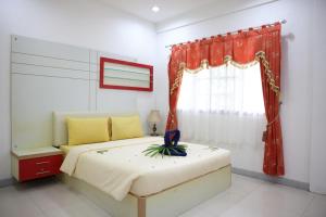 Schlafzimmer mit einem Bett und einem Fenster in der Unterkunft Bintan Service Apartment in Sebungsungai