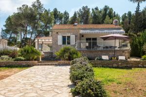 une maison avec un parasol devant une cour dans l'établissement Holiday House de Finis, à Sutivan