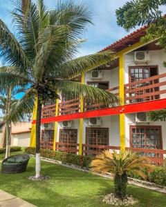 a building with a palm tree in front of it at Bem Bahia Hotel - Rede Bem Bahia in Porto Seguro