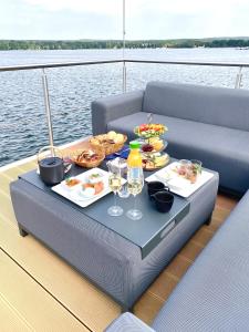einen Tisch mit einem Tablett mit Speisen und Getränken auf einem Boot in der Unterkunft TRAUMZEITBOOT auf dem Scharmützelsee Bad Saarow in Bad Saarow