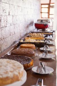 a buffet line of different types of cakes and pastries at Bem Bahia Hotel - Rede Bem Bahia in Porto Seguro