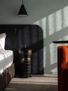 a bedroom with a bed and a night stand next to a table at Salamanca Suites in Hobart