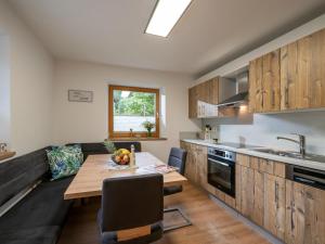 a kitchen with a wooden table and a dining room at Ferienwohnung Frieda in Ellmau