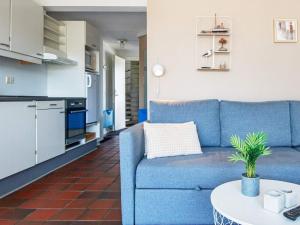 ein Wohnzimmer mit einem blauen Sofa und einem Tisch in der Unterkunft 4 person holiday home in Fan in Fanø