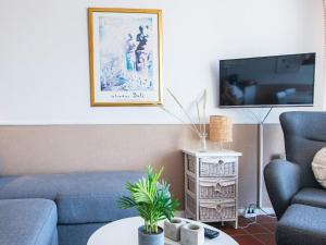 uma sala de estar com um sofá azul e uma televisão em 4 person holiday home in Fan em Fanø