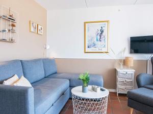 4 person holiday home in Fan في فانو: غرفة معيشة مع أريكة زرقاء وطاولة